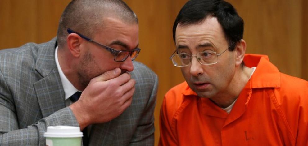 Larry Nassar, a former team USA Gymnastics doctor, talks with his defense attorney Matt Newburgh...