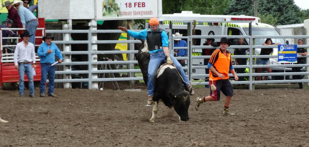 Connor Sandri, of Oamaru, holds on tight as he competes in the second-division bull ride at the...