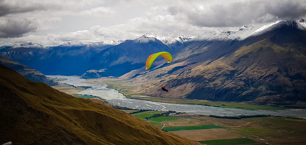 Tauranga's Rhys Akers soars near Treble Cone during the New Zealand Paragliding Open last week. Photo: Supplied