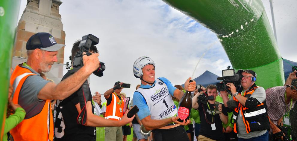 Sam Clarke cracks open the bubbly at the finish line after winning the Longest Day race of the...