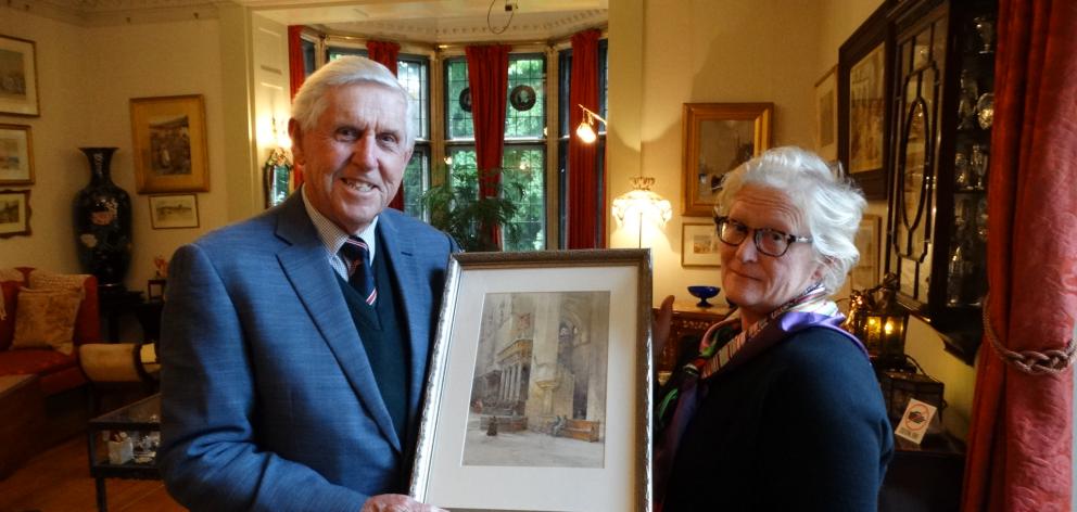 The drawing room at Olveston provides the backdrop as Auckland man John Hudson hands a painting by Sir Ernest George to Olveston manager Bronwyn Simes yesterday. PHOTO: BRENDA HARWOOD The drawing room at Olveston provides the backdrop as Auckland man John Hudson hands a painting by Sir Ernest George to Olveston manager Bronwyn Simes yesterday. PHOTO: BRENDA HARWOOD