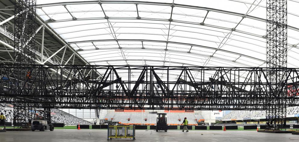 Workers assemble lighting racks at Forsyth Barr Stadium yesterday, before Ed Sheeran's three...