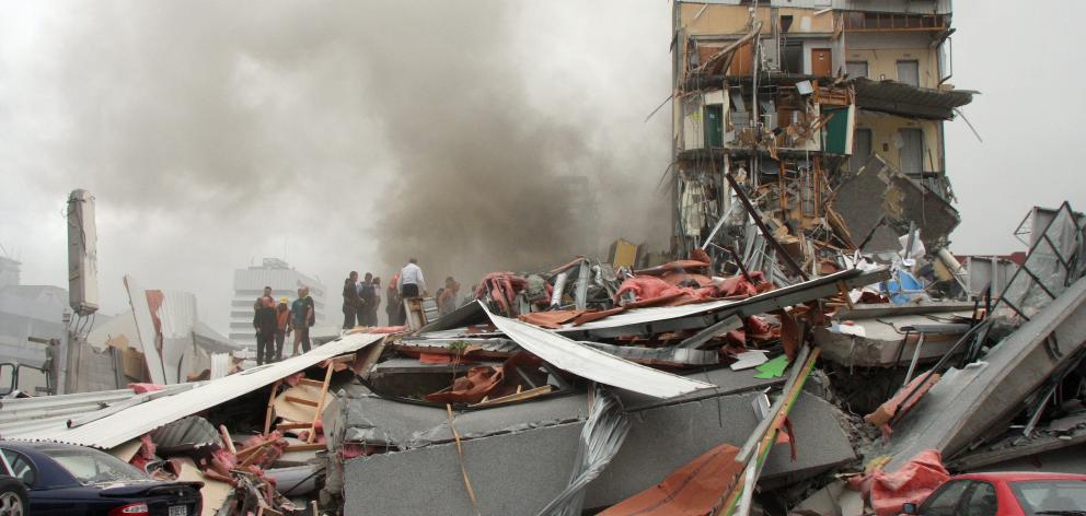 Police and volunteers work to rescue people trapped in the collapsed CTV building. Photo: Geoff Sloan