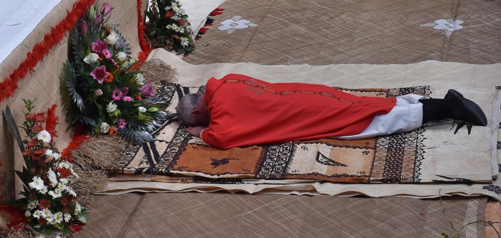 Bishop-elect Dooley prostrates himself during the Litany of the Saints, prior to his ordination...