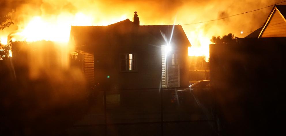 A view past houses in Dart St, Oamaru, of a fire in Regina Lane about 5am yesterday. Photo:...