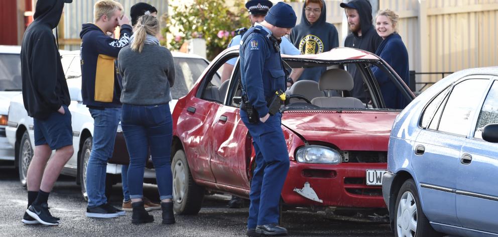 A group stands round a damaged car in Hyde St, Dunedin. Photo: Peter McIntosh