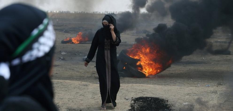 A female Palestinian demonstrator walks during a at the Israel-Gaza border. Photo: Reuters