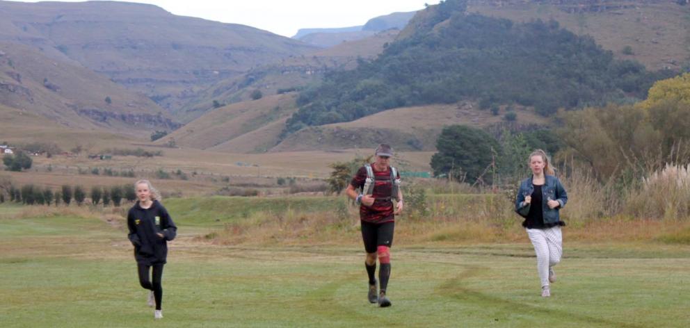 Glenn Sutton (middle) runs with daughters Ruby (left) and Emily as he reaches the 102km mark of the Ultra-Trail Drakensberg 100-mile (160.9km) race in South Africa. It was the first time he had seen them since the start of the race. Photo: Supplied