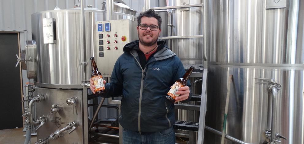 Altitude brewing partner Eliott Menzies shows off his award-winning beer. Photo: Josh Walton