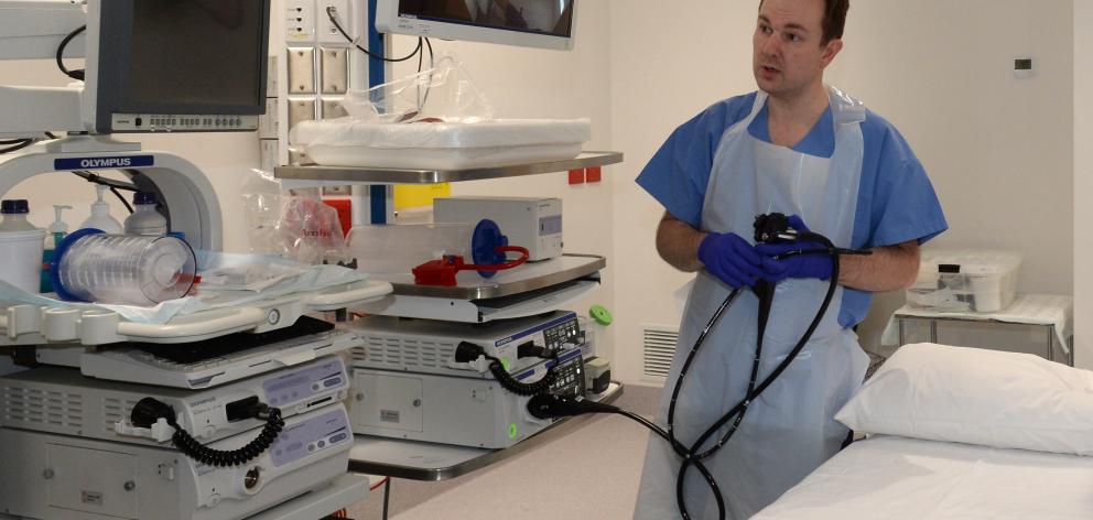 Gastroenterology clinical director Dr Jason Hill holds a gastroscope in one of the procedure...