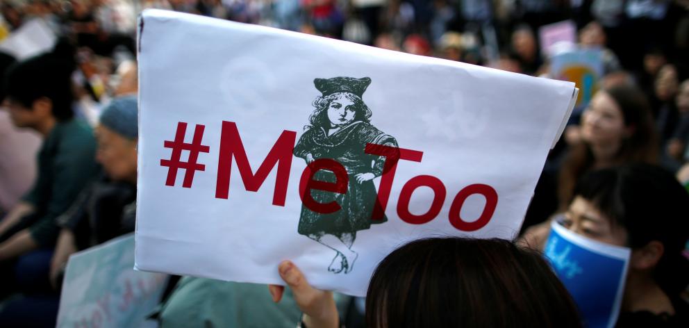 A protester raises a placard reading "#MeToo" during a rally against harassment in Tokyo. Photo: Reuters