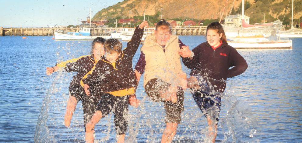 Deane Davison (71), trying the Friendly Bay water with her grandchildren, Eden (10), left,...