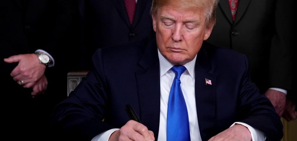 US President Donald Trump signs a memorandum on intellectual property tariffs on high-tech goods...