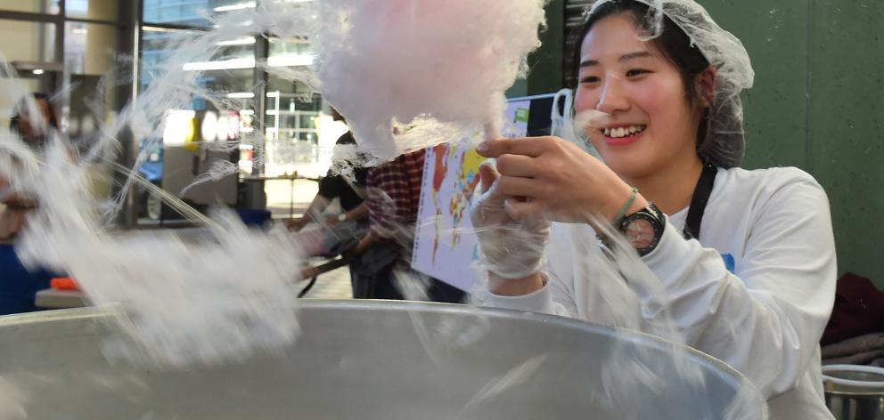Tweety Cheng, from Hong Kong, grapples with a tricky stick of candy floss at  the Cultural...