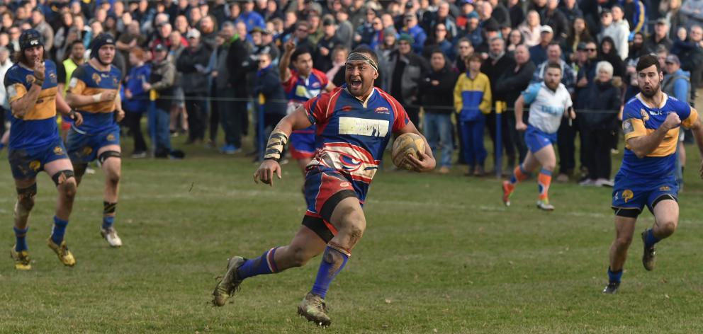 Harbour prop Giorgio Bower breaks through the Taieri defence to score a decisive try gives chase,...