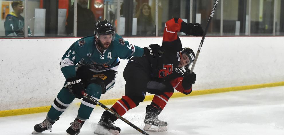 Dunedin Thunder player Brandon Egli (left) fends off Red Devils player Alex Egan during their...