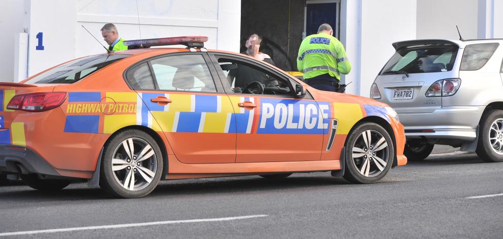 A victim of a road-rage attack in North Dunedin yesterday afternoon speaks to police in Duke St. Photo: Christine O'Connor