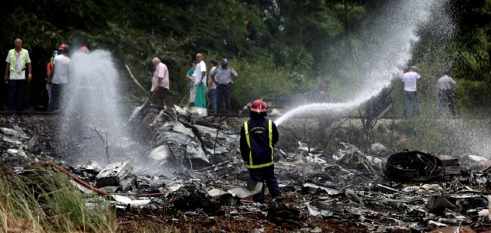 A firefighter works in the wreckage of a Boeing 737 plane that crashed in the agricultural area of Boyeros. Photo: Reuters