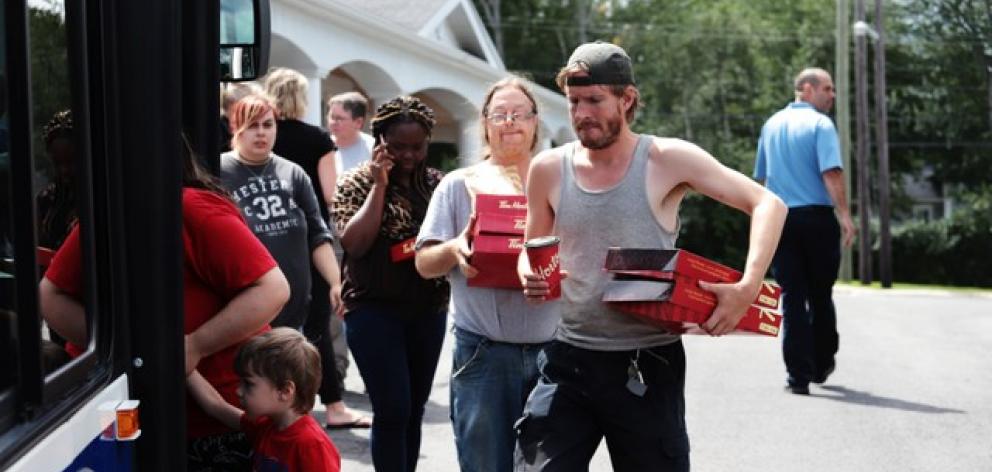 Evacuees Board Bus at the scene of a shooting incident in Fredericton. Photo: Reuters