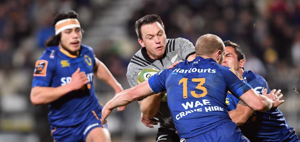 All Black fullback Ben Smith looks to burst through the tackle of Otago centre Matt Faddes as...