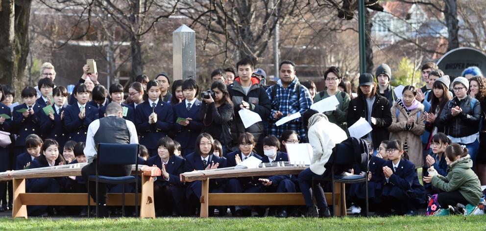 People gather in the Otago Museum reserve yesterday to commemorate the bombing of the Japanese...