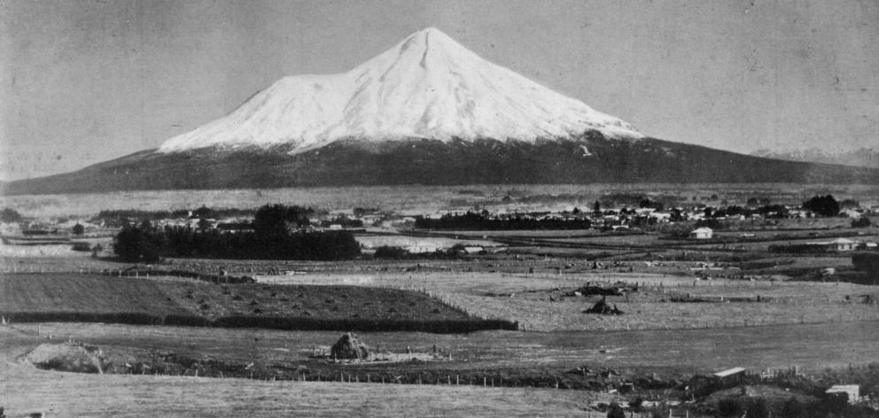 Mount Egmont, Taranaki, with the town of Stratford in the middle distance, after a heavy snowfall...