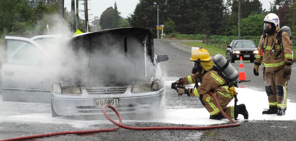 Firefighters from the Weston Volunteer Fire Brigade extinguish a car fire in Main Rd at Weston...