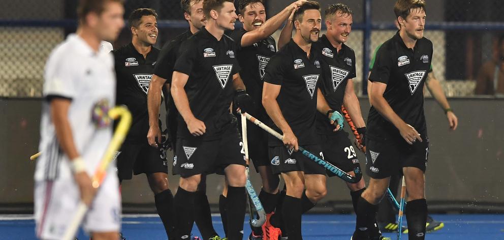 Kane Russell, of New Zealand, celebrates with team mates after scoring his side’s first goal...