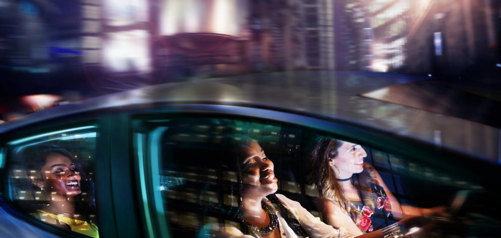 Young women driving in car on night out. Photo: Getty Images