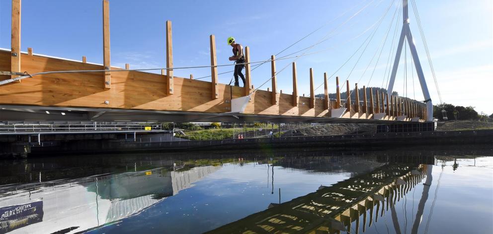 Water of Leith bridge project manager Walter Reikes, of Edifice construction, works on decking for the structure yesterday. Photo: Stephen Jaquiery