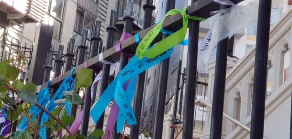 About 50 ribbons, signed with messages by victims and their supporters, were tied to the gates of St Mary of the Angels in Wellington last night. Photo: Dr Murray Heasley