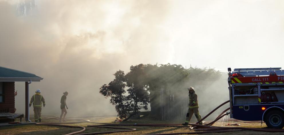 Firefighters battled a roaring garage fire in Albert Town last night. Photos: Sean Nugent