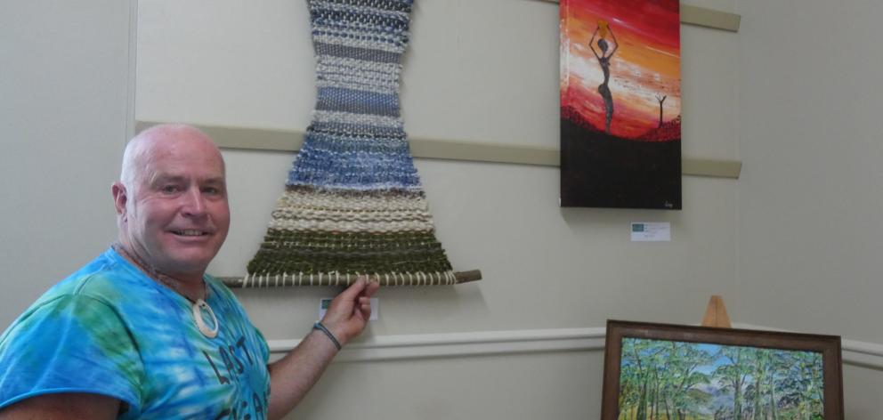 Riverton Community Arts Centre chairman Wayne Hill shows some of the art on display at the...
