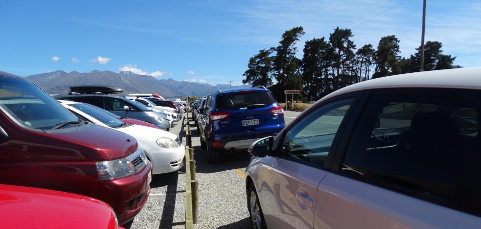 Cars parked on broken yellow lines outside the car park at the start of the Roys Peak track in...