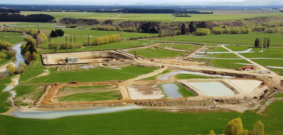 Waikaia Gold's mining area looking west, with sheet-piled cells in the background, water settling ponds in the foreground and the Waikaia River bottom right. The dredging subsequently worked its way over about 5km of paddocks.