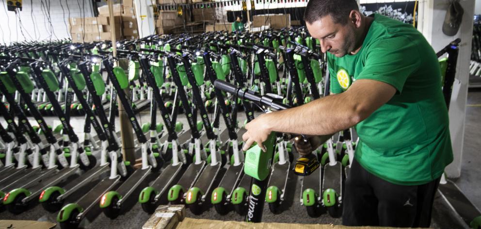 Mechanic Vlatko Jovanovski repairs Lime scooters in storage at Lime's warehouse in Kingsland,...