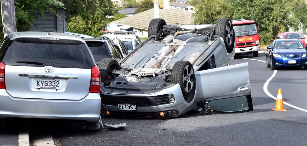 Dunedin police stop traffic on Kenmure Rd after a stolen car crashed and rolled on Sunday. PHOTO:...