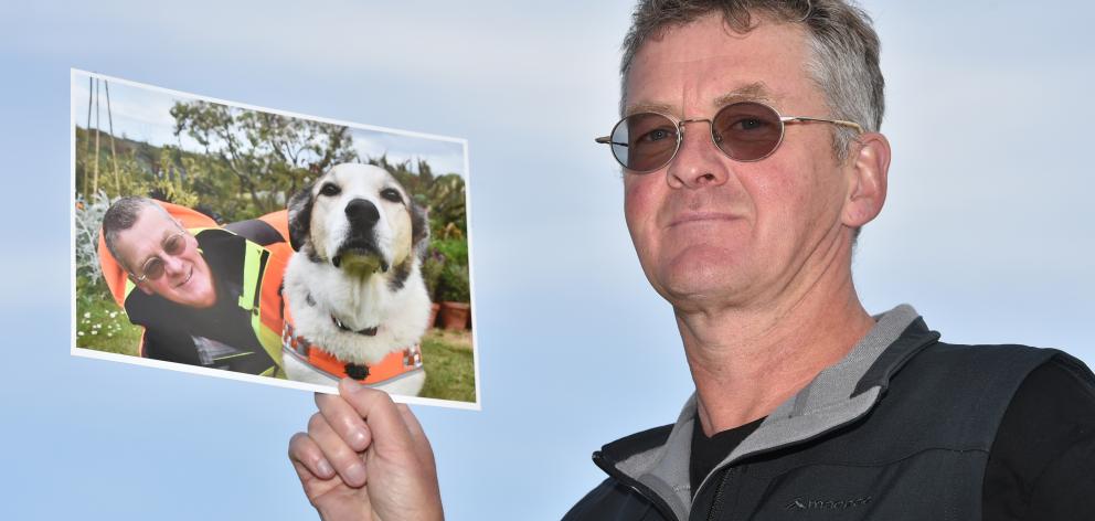 LandSAR volunteer Dermot Mayock holds a picture taken of him and his dog, Fin, when Fin retired...