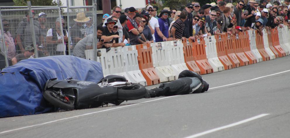 Motorcyclist Tony Campbell, of New Plymouth, lies on the track after crashing his Aprilia RSV...