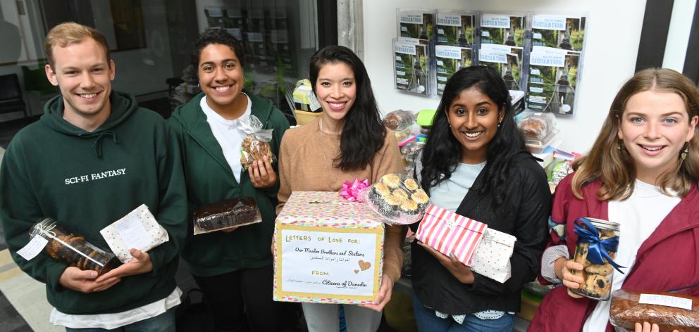 University of Otago Volunteer Centre co-ordinator Sze-En Watts (centre) and UniCrew volunteers (from left) Stefan Prince (23), Susana Jones (19), Ishani Sukumaran (22) and Grace Edmonds (22) receive baking and letters on campus yesterday. Photo: Linda Rob