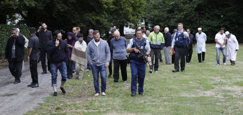 Police escort witnesses away from a mosque in central Christchurch. Photo: AP