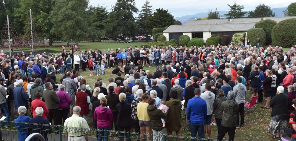 Mosgiel woman Chantelle Carran places flowers on the grass of Memorial Park during a vigil for the Christchurch mosque shootings. Photo: Peter McIntosh