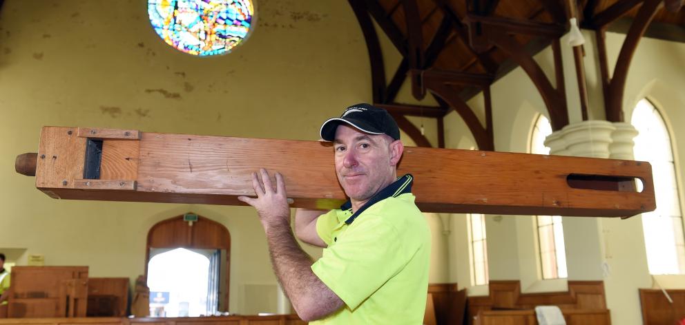 Kris Shaw, of the South Island Organ Company, removes an oak and mahogany organ pipe from the Lawton and Osborne organ in Maori Hill Presbyterian Church. Photo: Gregor Richardson