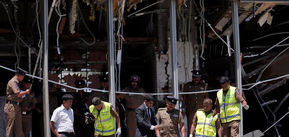 Crime scene officials inspect the explosion area at Shangri-La hotel in Colombo. Photo: Reuters