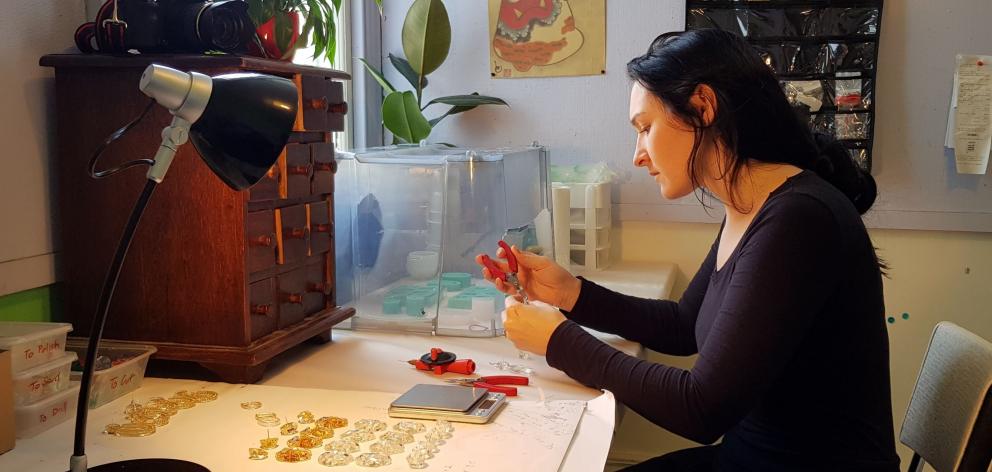 Little Constellation jewellery designer Maria Brett works on a pair of handcrafted earrings in...
