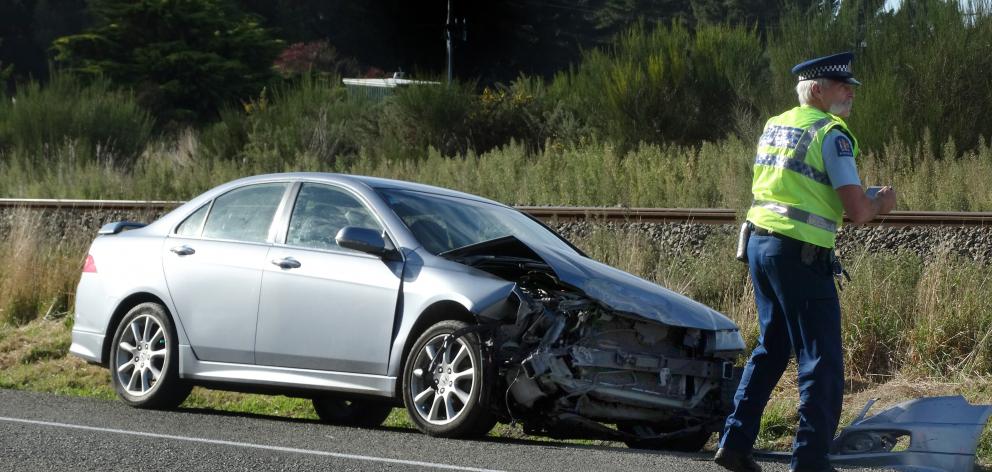 Senior Constable Bruce Dow, of Oamaru, checks a car that was struck by a train at a level...
