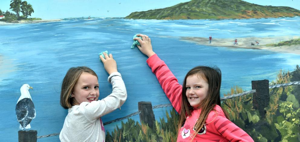 Taieri Beach School pupils and sisters Dannielle (10) and Indica (9) Hawkins clean the seagull droppings off the school's highly recognisable mural. Photo: Peter McIntosh