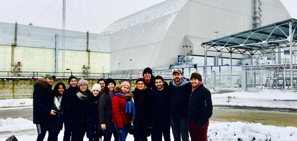 Standing in front of the new containment shield covering the remains of the exploded reactor are...