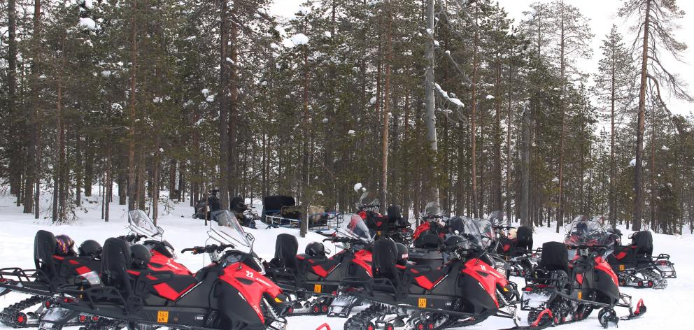 Snowmobiles on the edge of frozen Pikku-Mellalampi Lake.