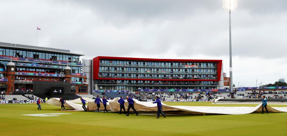 The covers came off and on during a four hour wait in vain for the game to resume, Photo: Reuters